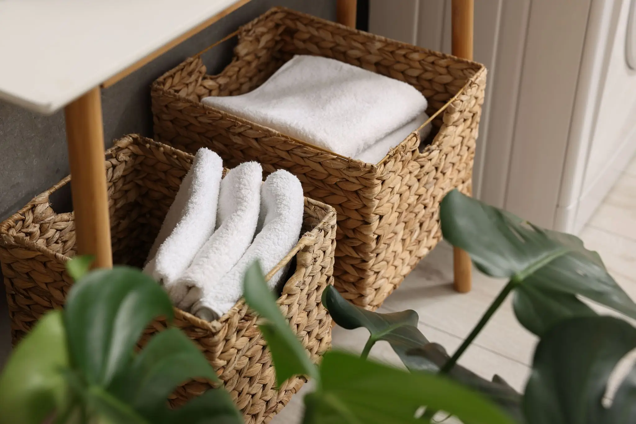 Woven baskets with white towels, green plants.